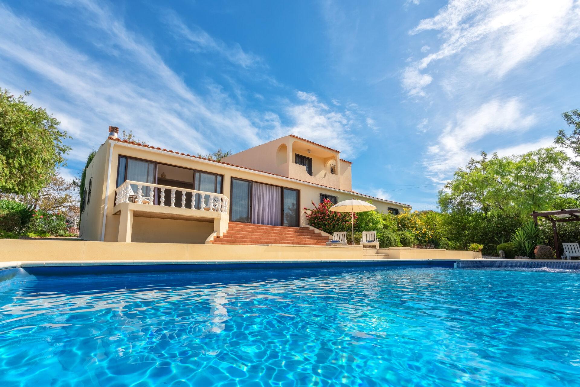 A luxury pool with clear blue water overlooking the garden villa. For rent to tourists.