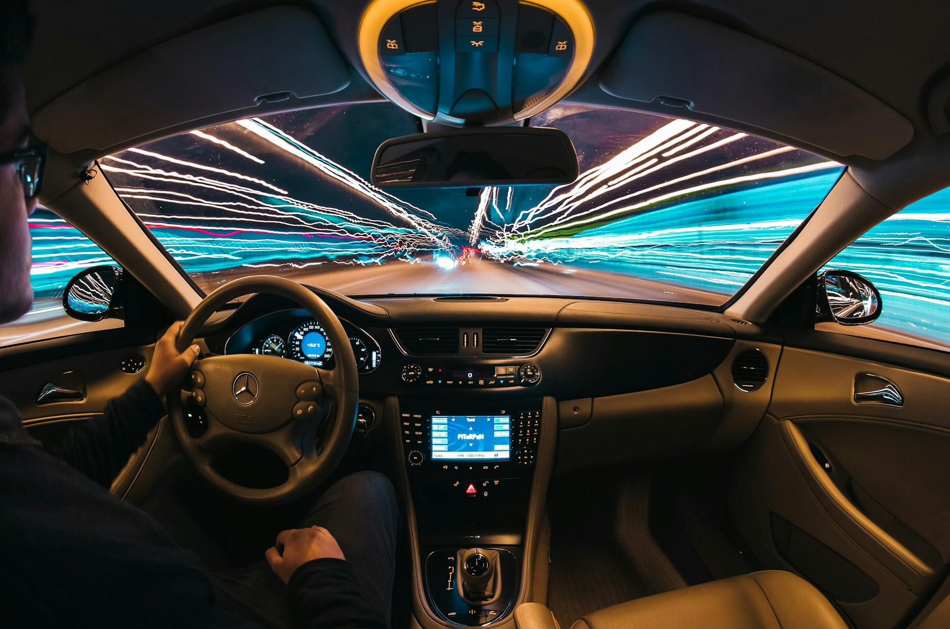 Interior view of a car driving at high speed with colorful light trails, highlighting the importance of hydrogen sensors in ensuring safety and efficiency in hydrogen-powered vehicles.